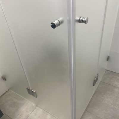 תא מקלחת עם דלת זכוכית וידיות מתכת