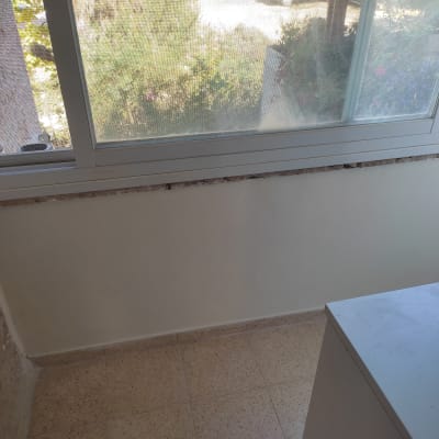 קיר צבוע בלבן ליד חלון זכוכית