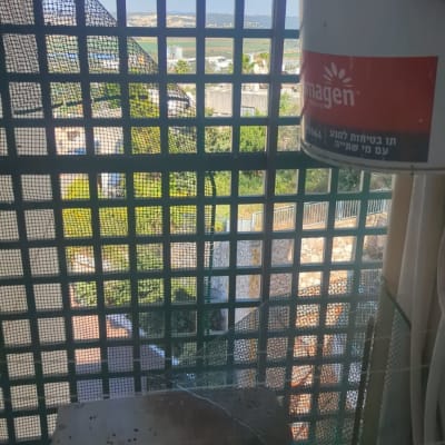 רשת למניעת כניסת יונים על חלון עם נוף חיצוני