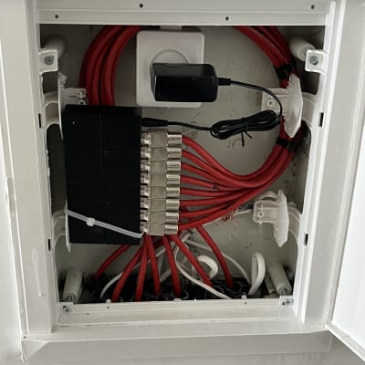 ארון תקשורת עם כבלים אדומים ומחבר רשת