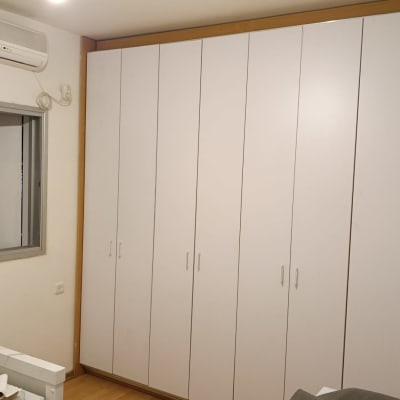 ארון בגדים לבן עם דלתות רבות בחדר שינה