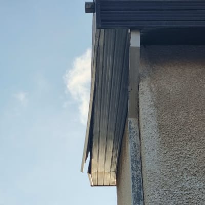 גג מתכת עם קורות תמיכה על קיר חיצוני