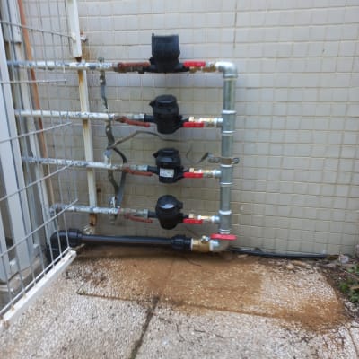 צינורות מים עם ברזים ומדי מים על קיר