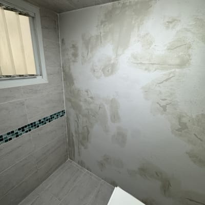 קיר עם טיח חלקי בחדר אמבטיה