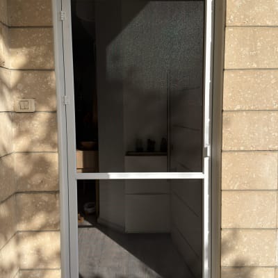 התקנת דלת רשת לבנה עם מסגרת אלומיניום בכניסה לבית