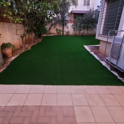 דשא סינתטי בגינה עם עצים מסביב