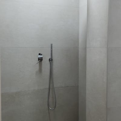 מקלחת עם אריחים צבעוניים וראש מקלחת עגול