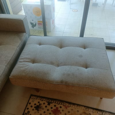 ספה אפורה ליד חלון זכוכית עם קופסה ברקע