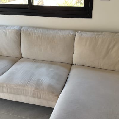 ספה בהירה ליד חלון עם אור יום