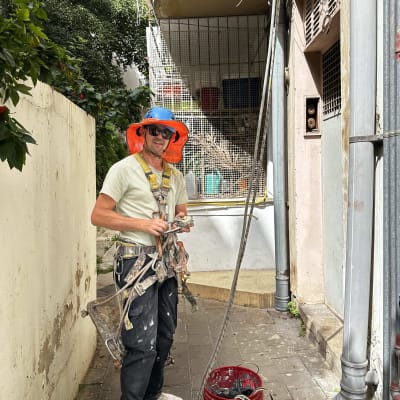 אדם עם ציוד עבודה ליד דלי וחוטים חשמליים