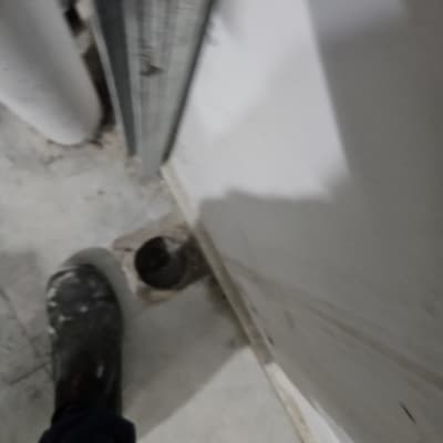 רגל עם נעל עבודה ליד חור ברצפה
