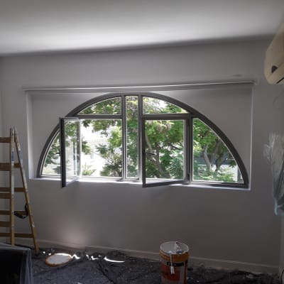 סולם, דלי צבע ומברשת על רצפה מכוסה בניילון