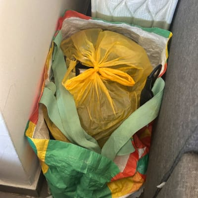 תיק גדול ושקית ארוזה המוכנים להובלה לצד ספה ומזרן