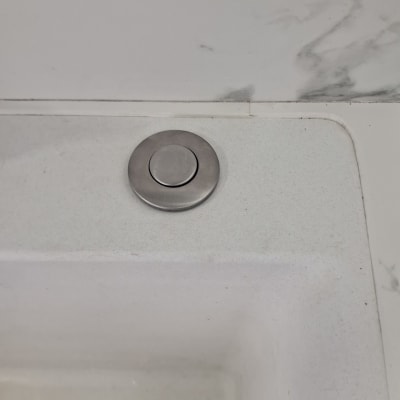 כיור עם כפתור נירוסטה על השיש