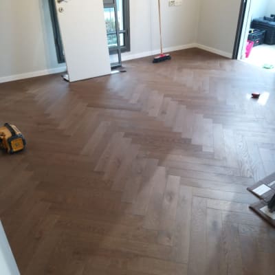 רצפת פרקט עץ בצורת זיגזג עם מטאטא