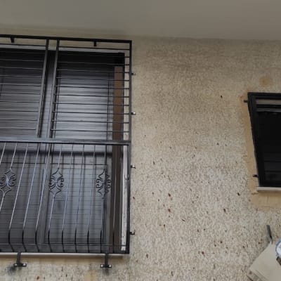 חלונות עם סורגים שחורים על קיר חיצוני