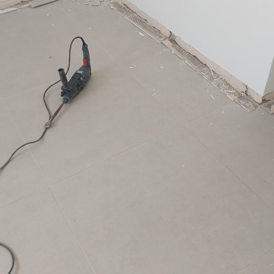 כלי עבודה על רצפה ליד קיר עם שקעי חשמל