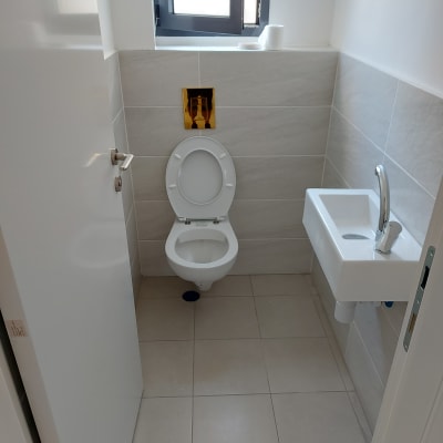 שירותים נקיים עם כיור קטן וברז כסוף