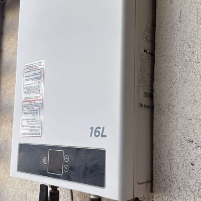 דוד גז מותקן על קיר עם צינורות חיבור