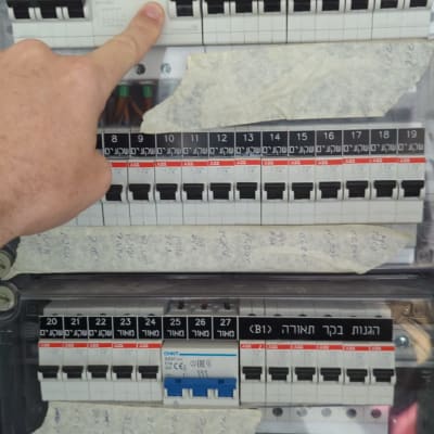 לוח חשמל עם מפסקים ואצבע מצביעה על מפסק