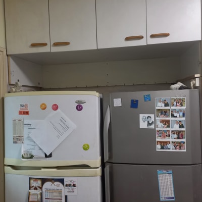 ארונות מטבח עם ידיות עץ מעל מקרר