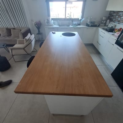 מטבח מודרני עם אי עץ, כיור וכלים על השיש