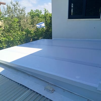 גג אלומיניום מותקן על מבנה עם נוף עצים ודגל ישראל ברקע