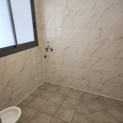 חדר אמבטיה עם אריחים נקיים ורצפה מרוצפת
