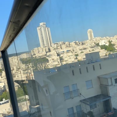 מעקה זכוכית עם נוף עירוני ברקע