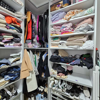ארון בגדים מאורגן עם מדפים מלאים בבגדים ונעליים