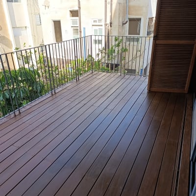 מרפסת עץ עם מעקה ברזל בבניין מגורים