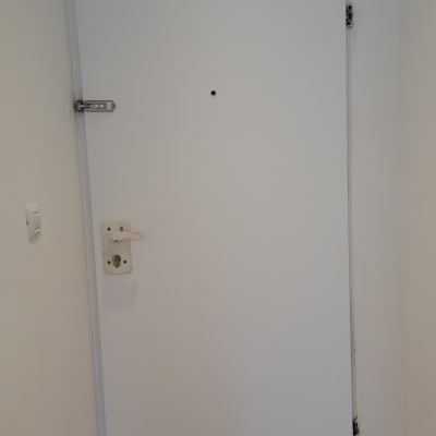 דלת לבנה עם מנעול ובריח מתכת