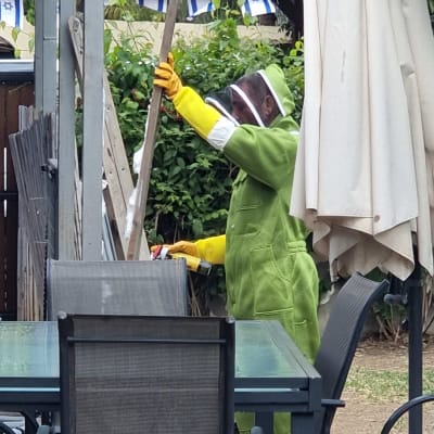 אדם בחליפת מגן ירוקה עם כפפות צהובות