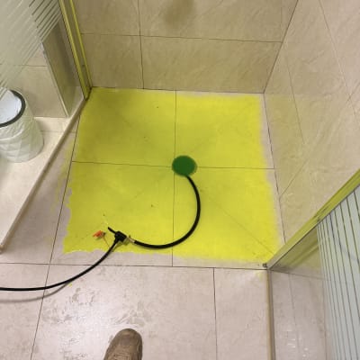 מקלחת עם צינור וכלי עבודה על הרצפה