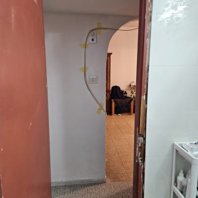 דלת פתוחה עם חוט חשמל מודבק לקיר