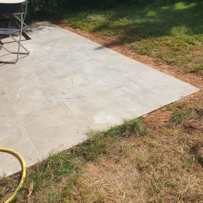 ריצוף חדש בגינה עם צינור צהוב על הקרקע