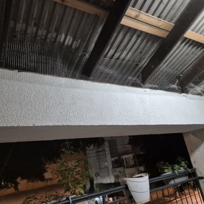 רשת מותקנת למניעת כניסת יונים מתחת לגג