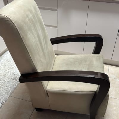 כיסא מרופד עם ידיות עץ על רצפה קרמית