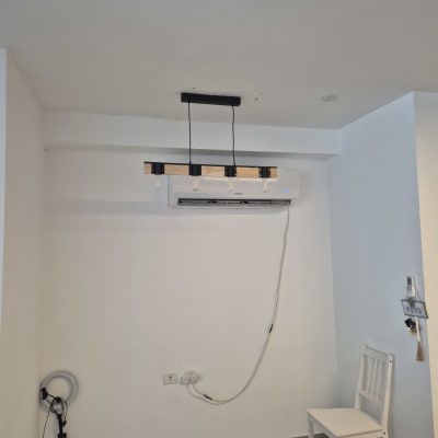 מנורה תלויה, כבל חשמל ושקע על קיר לבן