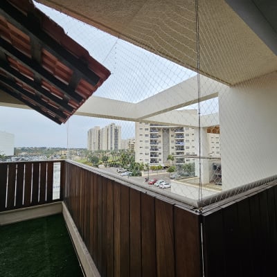 רשת למניעת כניסת יונים במרפסת עם גדר עץ