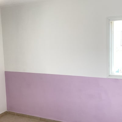 קיר צבוע בחצי סגול וחצי לבן עם חלון