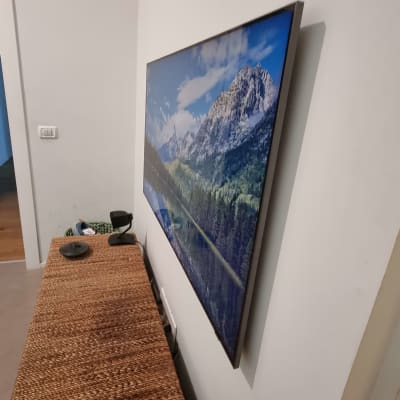 תמונה תלויה על קיר עם שקע חשמלי ליד