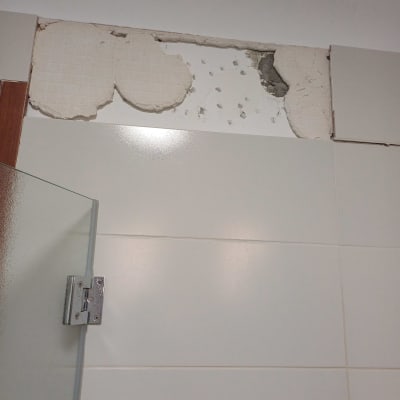 אריחים שבורים על קיר עם חור בתקרה