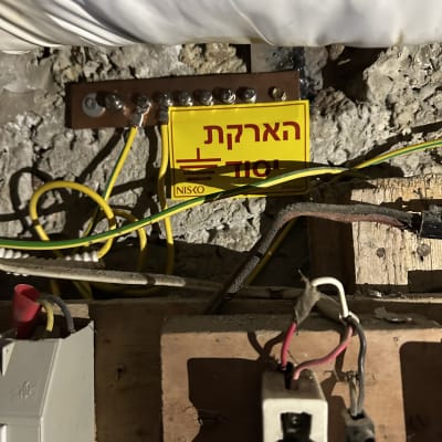 חיבורי חשמל עם שלט הארקה על קיר בטון