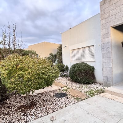 גינה עם שיחים ואבנים ליד בית