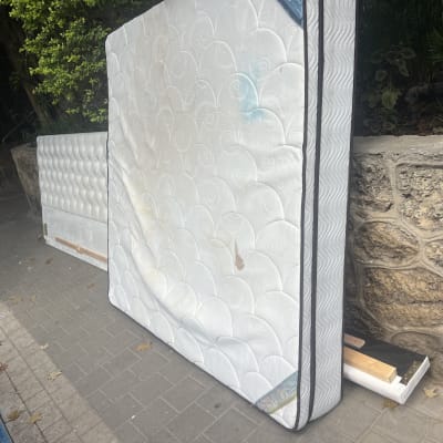 מזרנים מונחים על מדרכה ליד קיר אבן