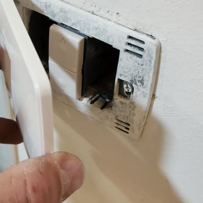 התקנת מתג חשמל בקיר על ידי חשמלאי