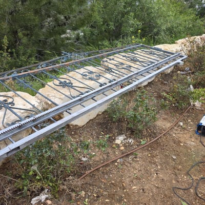 שער חשמלי עם מנוע וכלים בשטח פתוח