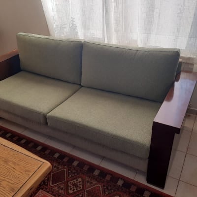 ספה ירוקה עם ריפוד מרופד ושולחן עץ