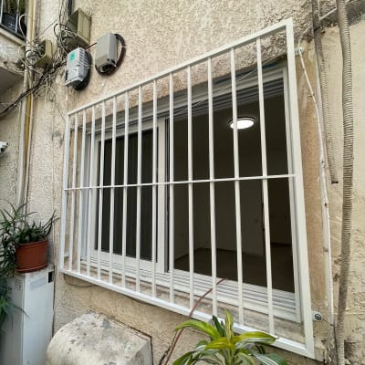 סורגי מתכת לבנים על חלון זכוכית